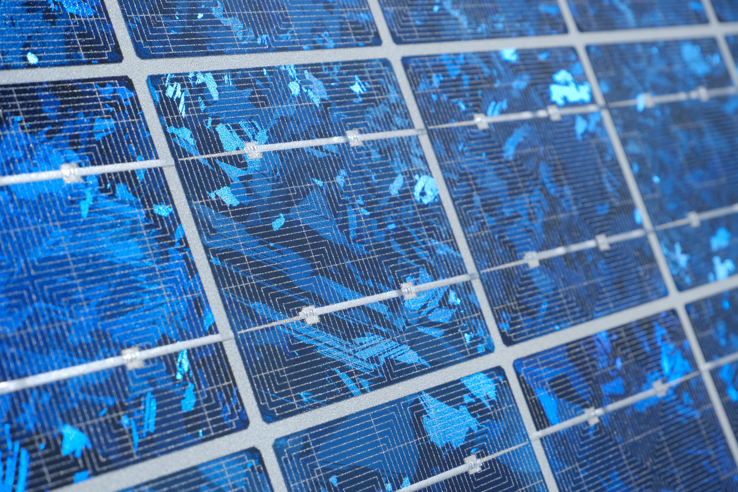 Primo piano di un pannello fotovoltaico policristallino, con il caratteristico effetto a mosaico bluastro