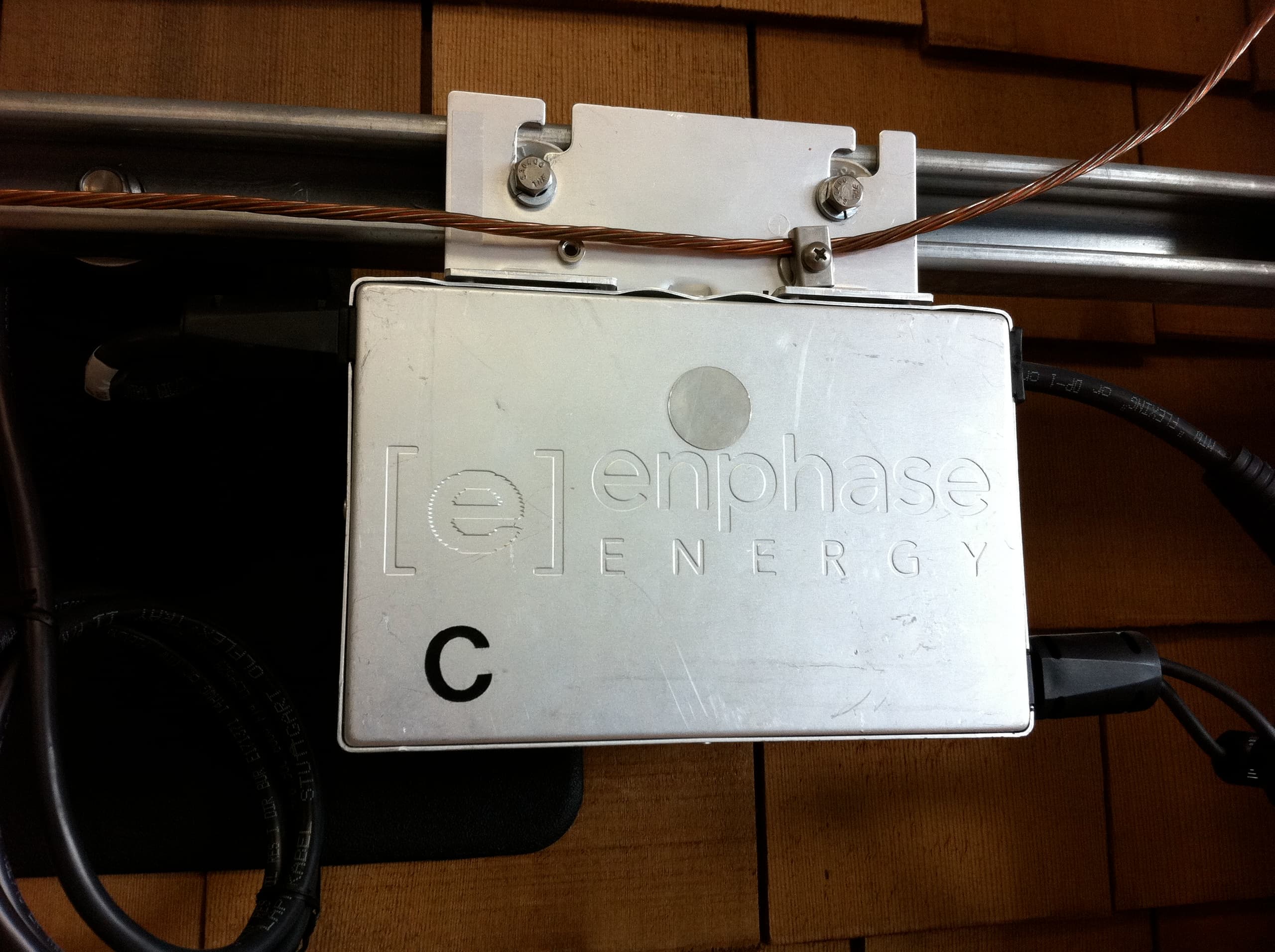 Microinverter Enphase M190 montato sul retro di un pannello fotovoltaico